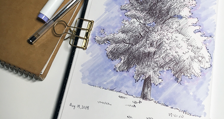 A photo of two sketchbooks, one with a page showing a ballpoint pen tree drawing.