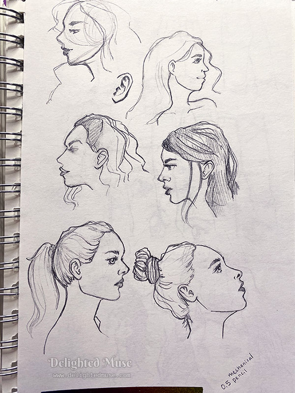 Sketchbook page of rough sketches of faces in profile