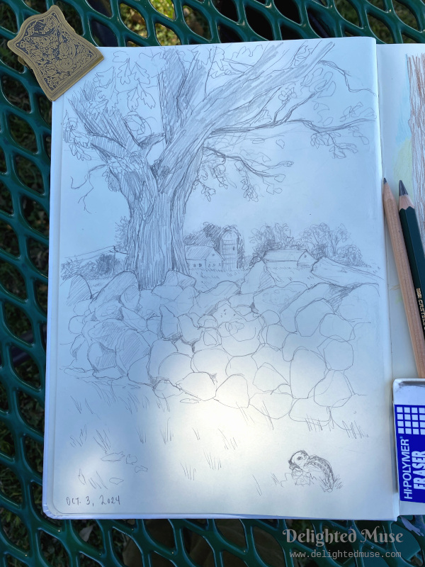 A sketchbook page with a graphite pencil of an oak tree and rock wall. In the background are barns and a silo. In the lower right foreground is a doodle of a ground squirrel.